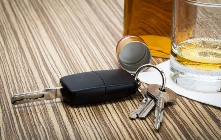 Can You Get a DUI When Not Driving in Pensacola? 1 Man in suit smirks, holding "Expunged DUI" document near Pensacola sign.