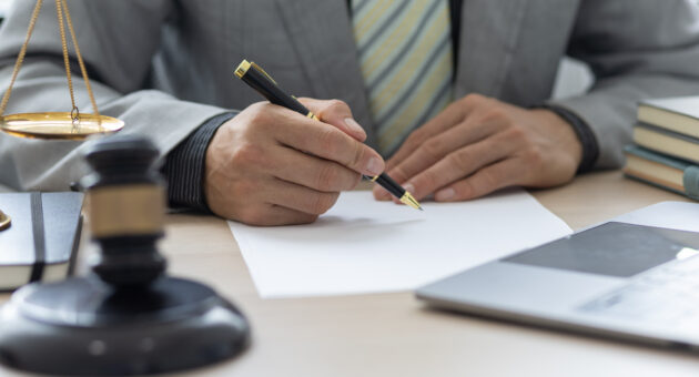Public defender consults client in Pensacola courtroom.